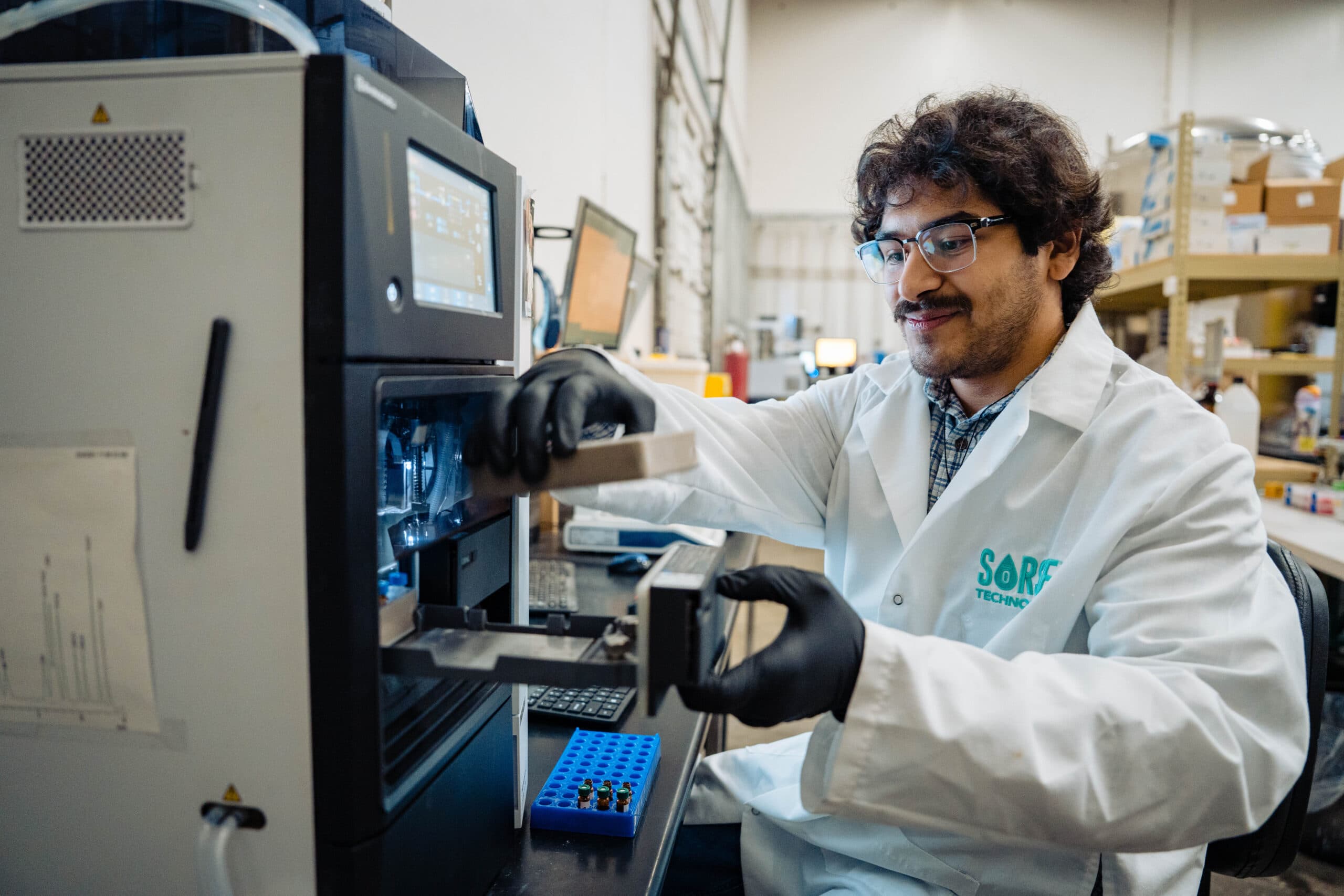 SōRSE scientist loading samples into an HPLC analyzer for stability testing